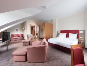 ein Hotelzimmer mit einem großen Bett und Möbeln in der Unterkunft Hotel Hachinger Hof in Oberhaching