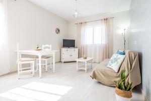 a white living room with a table and a bed at Aguamarina in Tarajalejo