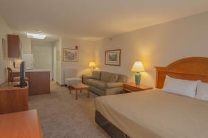 Habitación de hotel con cama y sofá en Smart Suites on the Hill, en South Burlington