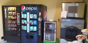 a cocacola soda machine next to a drink dispenser at Microtel Inn & Suites by Wyndham Delphos in Delphos