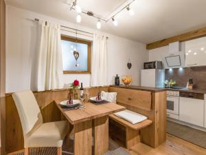 cocina con mesa de madera y sillas en una habitación en Appartement Baumgartner, en Westendorf