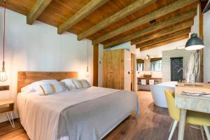 a bedroom with a large bed and a dining room at Hotel Mas la Ferreria in La Vall de Bianya