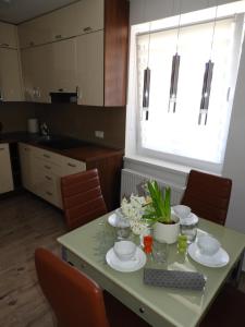 a kitchen with a table with plates and flowers on it at Bajka Anity in Wilkasy