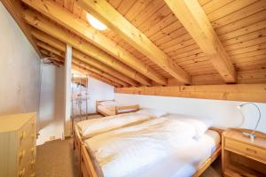 1 dormitorio con 1 cama en una habitación con techos de madera en Casa Pignola, en Falera