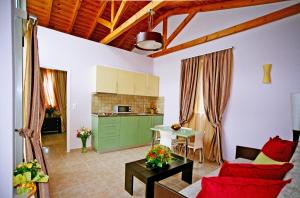 a living room with a red couch and a kitchen at PIERIDES SUITES in Kardamyli
