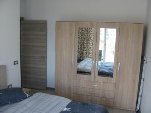 a bedroom with a large wooden cabinet with a bed at Apartamente Azzurro on the beach in Mamaia Sat/Năvodari +21 photos