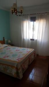 エル・ボスケにあるApartamento Maria Encarnacionのベッドルーム1室(花の咲く毛布、窓付)