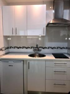 a kitchen with white cabinets and a sink at Castillo Santa Clara in Torremolinos