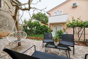 un patio con 2 sedie e un'altalena di Villa Dvori a Bašanija (Bassania)
