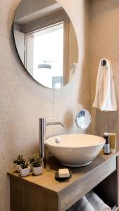 La salle de bains est pourvue d'un lavabo et d'un miroir. dans l'établissement Kiotari Akti Beachfront Villas, à Gennadi