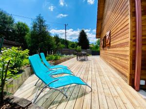 a pair of blue chairs sitting on a wooden deck at Le Hygge Chalet Gérardmer-Spa in Anould