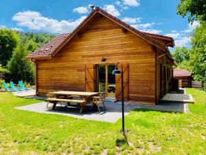 a log cabin with a picnic table in front of it at Le Hygge Chalet Gérardmer-Spa in Anould