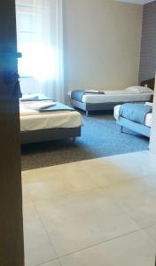 A bed or beds in a room at Zajazd u Sosny