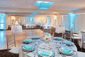 un salón de banquetes con mesas y sillas blancas en Nantasket Beach Resort en Hull