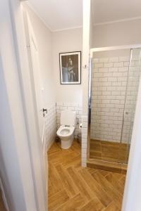 a bathroom with a toilet and a glass door at Maniu 31 Apartments & Rooms in Oradea