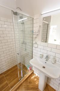 a white bathroom with a sink and a shower at Maniu 31 Apartments & Rooms in Oradea