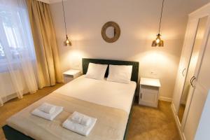 a bedroom with a large bed with two white pillows at Maniu 31 Apartments & Rooms in Oradea