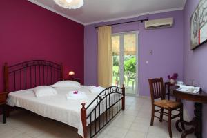 a bedroom with a bed and a desk and a window at The Filoxenia Apartments, Nikiana in Nikiana