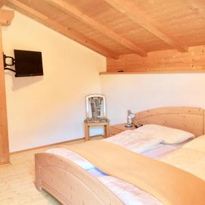 1 dormitorio con 1 cama y TV en la pared en Apartments Bernard, en Aldino
