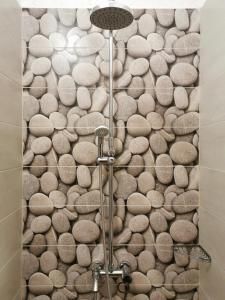 a bathroom with a shower with rocks on the wall at Rila Apartment in Sofia