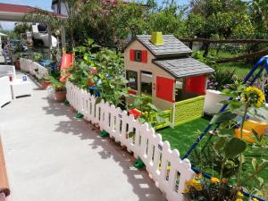 uma casa de brinquedos num jardim com uma cerca em La Gramigna Villette em Briatico