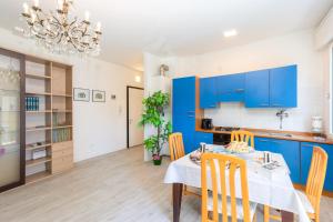 Casa Serenissima في ميستر: مطبخ وغرفة طعام مع دواليب زرقاء وطاولة وكراسي