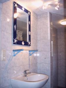 ein Bad mit einem Waschbecken und einem Spiegel in der Unterkunft Ostseeurlaub-Barth in Barth