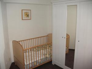 a baby crib in a room with a mirror at Ostseeurlaub-Barth in Barth