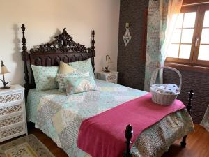 a bedroom with a large bed with a pink blanket at Casa de Mos in Aboim