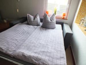 1 dormitorio con cama con almohadas y ventana en An der Elde mit Boot en Lübz