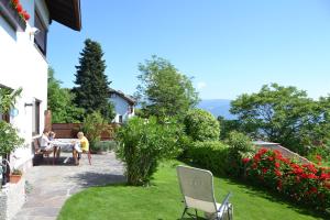 a couple sitting at a table in a garden at Haus Marion in Appiano sulla Strada del Vino