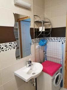 ein Bad mit einem Waschbecken und einem Spiegel in der Unterkunft Gyöngy Apartman in Keszthely