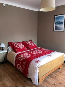 Condamine-Châtelard的住宿－La Condaminoise，一间卧室配有一张带红色枕头的床