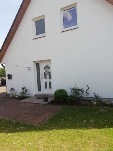 a white house with a door and a window at Meyers Ferienwohnung in Elmlohe