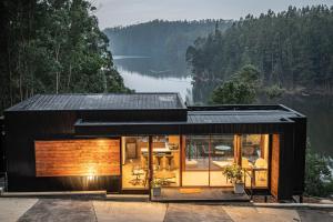 a black house with a view of a lake at Pura Lodge in Concepción