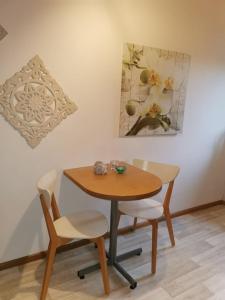 uma mesa e duas cadeiras e uma mesa e um quadro em casa Martinez em Rollesbroich