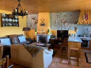 cocina y sala de estar con sofá y mesa en Casa de Mos, en Aboim