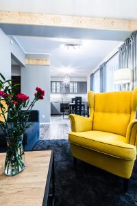 a living room with a yellow couch and a table at Nosal Hill Apartments&Spa in Zakopane