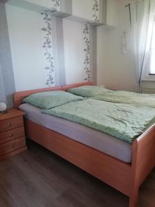 ElmloheにあるMeyers Ferienwohnungのベッドルーム1室(緑のシーツが敷かれたベッド1台、窓付)