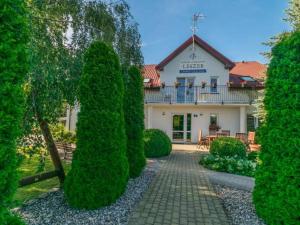 a building with a balcony and trees in front of it at Przedsiębiorstwo Turystyczne "SOL" in Grzybowo