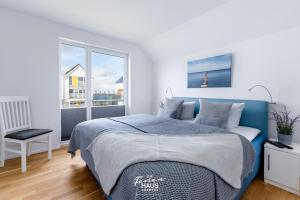 a bedroom with a blue bed and a window at Nordkap in Olpenitz