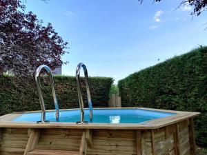 a hot tub with three metal faucets in a garden at LV Holidays 2 in Savigny-en-véron