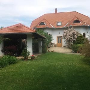 ein weißes Haus mit einem roten Dach und einem Hof in der Unterkunft Frutta Villa in Cserszegtomaj