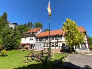 een gebouw met een vlag ervoor bij Hotel Pension Gelpkes Mühle in Bad Sachsa