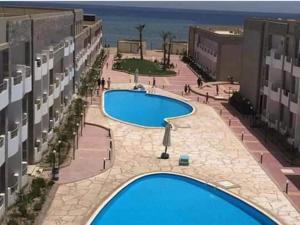 uma vista panorâmica de duas piscinas num edifício em Cecilia Beach Resort em Hurghada