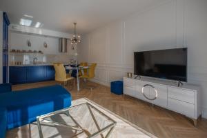 ein Wohnzimmer mit einem großen TV und einem Tisch in der Unterkunft CITYSTAY Św.Barbary Apartment in Danzig