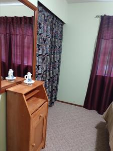 1 dormitorio con tocador, espejo y cortinas en Hall Creek Cabin, en Packwood