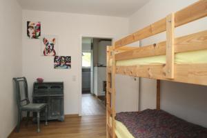 a bedroom with two bunk beds and a desk at Ferienhaus zum Medemufer in Otterndorf