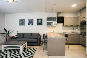 a kitchen and living room with a couch and a table at Murano Apartaments in Warsaw