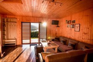 a living room with a couch and a table at Chaty na Cholewicy Domki Całoroczne in Solina